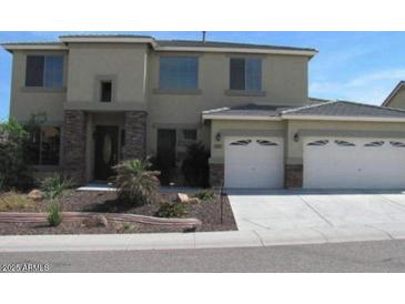 Two-story home featuring a two car garage, front yard with desert landscaping and neutral stucco and stone accents at 6619 W Cordia Ln, Phoenix, AZ 85083