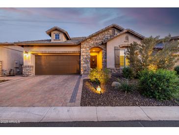 Charming home featuring stone accents, a brick driveway, and well-maintained landscaping at 6929 E Quill St, Mesa, AZ 85207