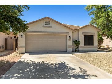 Charming single-story home with neutral stucco, a two-car garage, and desert landscaping at 9343 W Harmony Ln, Peoria, AZ 85382