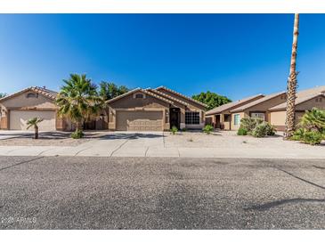 Charming single-story home with a well-manicured lawn and a two-car garage at 16242 W Maui Ln, Surprise, AZ 85379