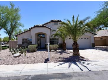 Charming single-story home with desert landscaping, palm trees, and a two-car garage at 1679 E Oakland St, Gilbert, AZ 85295