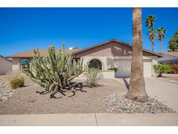 Charming single story home featuring desert landscaping, a two-car garage and arched entryway windows at 17244 N 36Th Ln, Glendale, AZ 85308