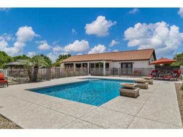 Backyard pool with tiled coping, outdoor seating and an exterior view of the home at 18132 E Vencino St, Gilbert, AZ 85298
