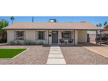 Charming single story home featuring neutral paint, desert landscaping, and a covered porch with seating at 1937 E Loyola Dr, Tempe, AZ 85282