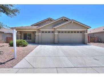 Charming single-story home with a well-manicured lawn and a three-car garage at 22121 N Greenland Park Dr, Maricopa, AZ 85139