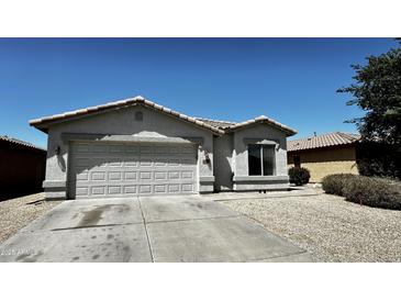 Charming single-story home with a two-car garage, desert landscaping and a tile roof at 43890 W Bedford Dr, Maricopa, AZ 85138