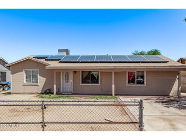 Single-story home featuring solar panels, fenced front yard, neutral paint, and covered entry at 6814 W Berkeley Rd, Phoenix, AZ 85035