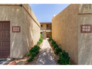 Inviting walkway with green landscaping leads to condo units in a well-maintained complex at 8301 N 21St Dr # F102, Phoenix, AZ 85021
