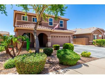 Charming two-story home features a well-manicured front yard with lush greenery and a welcoming facade under a clear blue sky at 13123 W Cottontail Ln, Peoria, AZ 85383