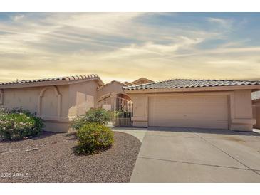 Charming single-story home with a well-maintained yard and a two-car garage at 14235 W Shawnee Trl, Surprise, AZ 85374