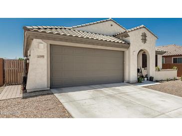 Charming home with a large garage, concrete driveway, and a low-maintenance desert-style landscape at 25915 W Tina Ln, Buckeye, AZ 85396