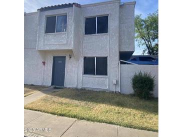 Two-story townhome featuring a textured facade, dual windows, and a front door with address numbers at 5233 N 42Nd Dr, Phoenix, AZ 85019