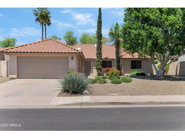 Charming home with a two-car garage, desert landscaping, and a well-maintained tile roof at 5758 E Fox St, Mesa, AZ 85205