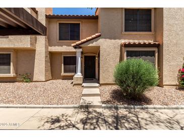 Charming townhome featuring a covered carport, desert landscaping, and inviting front entryway at 921 W University Dr # 1232, Mesa, AZ 85201