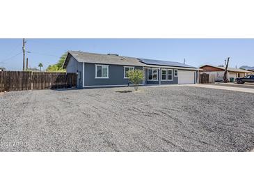 Charming single-story home featuring solar panels, a gravel front yard and a side garage at 11012 E Elton Ave, Mesa, AZ 85208