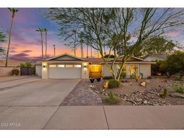 Charming single-story home with a well-manicured desert landscape and a welcoming entrance at twilight at 11822 S Coconino St, Phoenix, AZ 85044