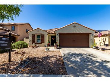Charming single-story home features a well-manicured front yard, a two-car garage, and desert landscaping at 14112 W Larkspur Dr, Surprise, AZ 85379