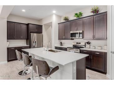 Spacious kitchen featuring an island with bar seating and dark cabinets at 3852 E Bartlett Way, Chandler, AZ 85249