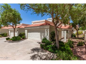 View of home with a terracotta roof, lush green landscaping, and a gated front entrance at 4225 N 21St St # 22, Phoenix, AZ 85016