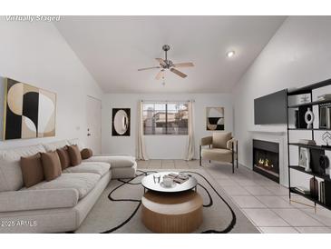 Bright living room featuring a white couch, fireplace, ceiling fan, and stylish decor at 533 W Guadalupe Rd # 2126, Mesa, AZ 85210