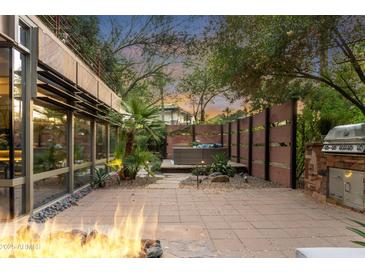 Relaxing patio features a fire pit, built-in grill, and hot tub area perfect for entertaining at 7117 E Rancho Vista Dr # 1012, Scottsdale, AZ 85251