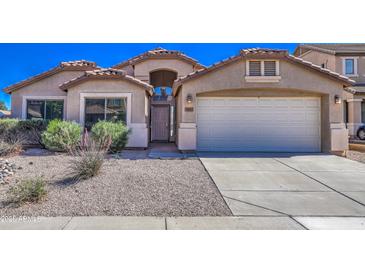 Charming single-story home with desert landscaping, arched entry, and two-car garage at 17617 W Corrine Dr, Surprise, AZ 85388