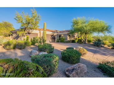 Beautiful desert landscaping enhances this home with a circular driveway and attached garages at 19947 N 94Th Way, Scottsdale, AZ 85255