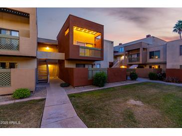 Cozy condo exterior featuring well-maintained lawn and private balcony with decorative lattice at 3500 N Hayden Rd # 710, Scottsdale, AZ 85251