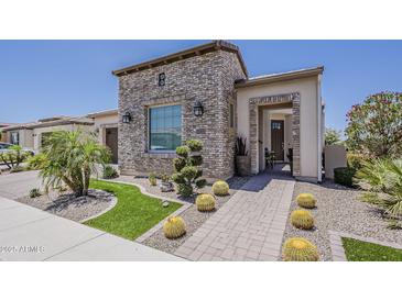 Charming home featuring a stone facade, desert landscaping, and a welcoming brick walkway at 35486 N Morello Dr, Queen Creek, AZ 85140