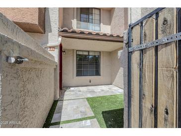 Inviting townhome entry featuring stone pavers, a touch of green turf, and gate access to the cozy front patio at 818 S Westwood -- # 101, Mesa, AZ 85210