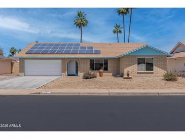 Charming single-story home featuring solar panels and a well-maintained desert landscape at 962 W Keating Ave, Mesa, AZ 85210