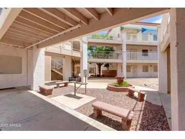 Charming community courtyard with seating, grilling area, and mature trees offering a relaxing outdoor space at 12123 W Bell Rd # 219, Surprise, AZ 85378