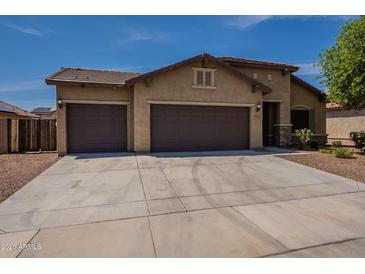 Charming single-story home featuring a three-car garage and a well-maintained desert landscape at 17531 W Fetlock Trl, Surprise, AZ 85387