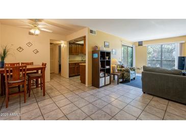Inviting living space featuring tile floors, dining area, and a view into the kitchen at 3131 W Cochise Dr # 144, Phoenix, AZ 85051