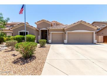 Charming single-story home boasts a two-car garage, desert landscaping, and an American flag at 927 S Ash St, Gilbert, AZ 85233