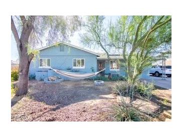 Charming single-story home featuring a front yard with mature trees and a relaxing hammock at 2335 W Campus Dr, Phoenix, AZ 85015