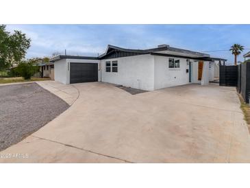 An exterior view of a modern home showcasing the garage and sleek design at 3002 W Mandalay Ln, Phoenix, AZ 85053