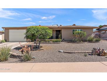 Charming single-story home with desert landscaping, an attached garage, and a tidy facade at 6448 E Des Moines St, Mesa, AZ 85205