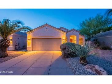 Charming single-story home with a well-manicured front yard and a spacious two-car garage at twilight at 8158 E Rita Dr, Scottsdale, AZ 85255