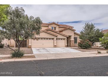 Charming two-story home features a three-car garage, desert landscaping, and a tile roof at 8766 W Hayward Ave, Glendale, AZ 85305