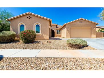 Inviting single-story home showcasing desert landscaping, a two-car garage, and a welcoming entrance at 16860 W Soft Wind Dr, Surprise, AZ 85387