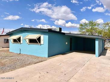 Charming single-story home with a blue exterior, a covered carport, and desert landscaping at 2258 E Alpine Ave, Mesa, AZ 85204