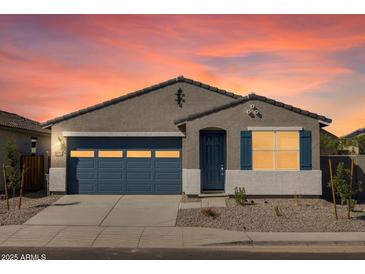 Charming single-story home featuring a blue garage door and shutters against a grey stucco exterior and landscaped front yard at 37153 W Prado St, Maricopa, AZ 85138