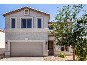 Two-story home featuring a beige stucco facade, neutral trim, and a two-car garage at 379 E Cheyenne Rd, San Tan Valley, AZ 85143