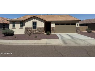 Charming single story home featuring stone accents, desert landscaping, and an attached two car garage at 6713 S 76Th Dr, Laveen, AZ 85339