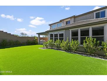 Backyard view of the new turf lawn, landscaping, and home at 7180 W Tombstone Trl, Peoria, AZ 85383