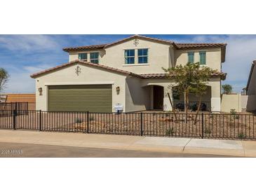Charming two-story home featuring a tan exterior, terracotta roof, a garage and a well-manicured front yard at 12712 W Corona Ave, Avondale, AZ 85323