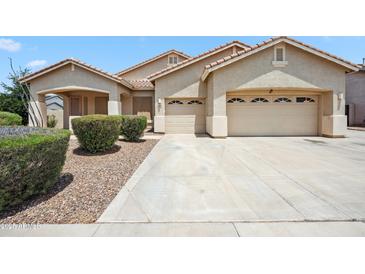 Charming single-story home with a neutral color scheme, well-maintained landscaping, and a spacious three-car garage at 4414 W Monte Way, Laveen, AZ 85339