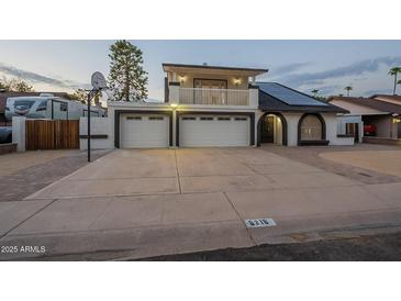 Two-story home featuring two-car garage, balcony, solar panels, and unique dark trim detail at 6216 W Poinsettia Dr, Glendale, AZ 85304