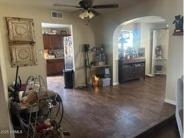 Open living room with tile flooring, ceiling fan, and views into the kitchen and dining areas at 1841 S Spruce --, Mesa, AZ 85210